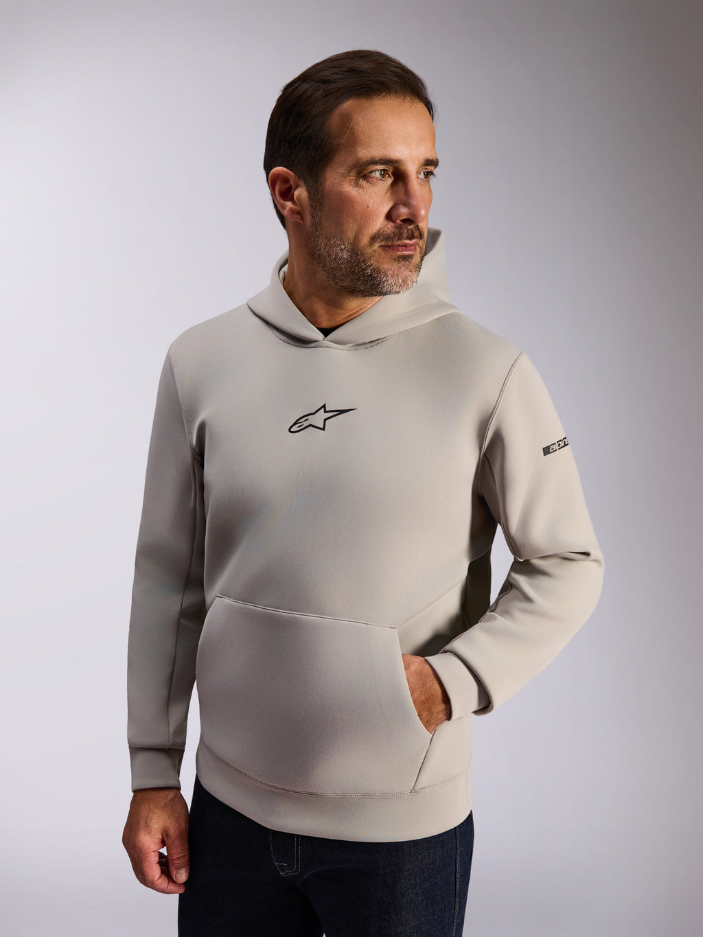 Alpinestars Insight Hoodie, streetwear casual lifestyle, lã cinzento cimento, logótipo Astars preto na frente, bolso canguru, logótipo na manga, capuz forrado com rede, vestuário moderno inspirado no desporto motorizado