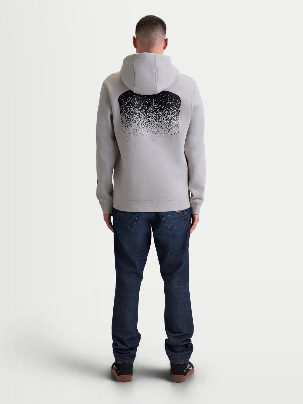 Alpinestars camisola com capuz Obsessed, camisola de fleece para homem em cinzento cimento e preto, vista traseira com um grande gráfico MX em gradação, vestuário casual inspirado no desporto motorizado com capuz e acabamentos canelados.