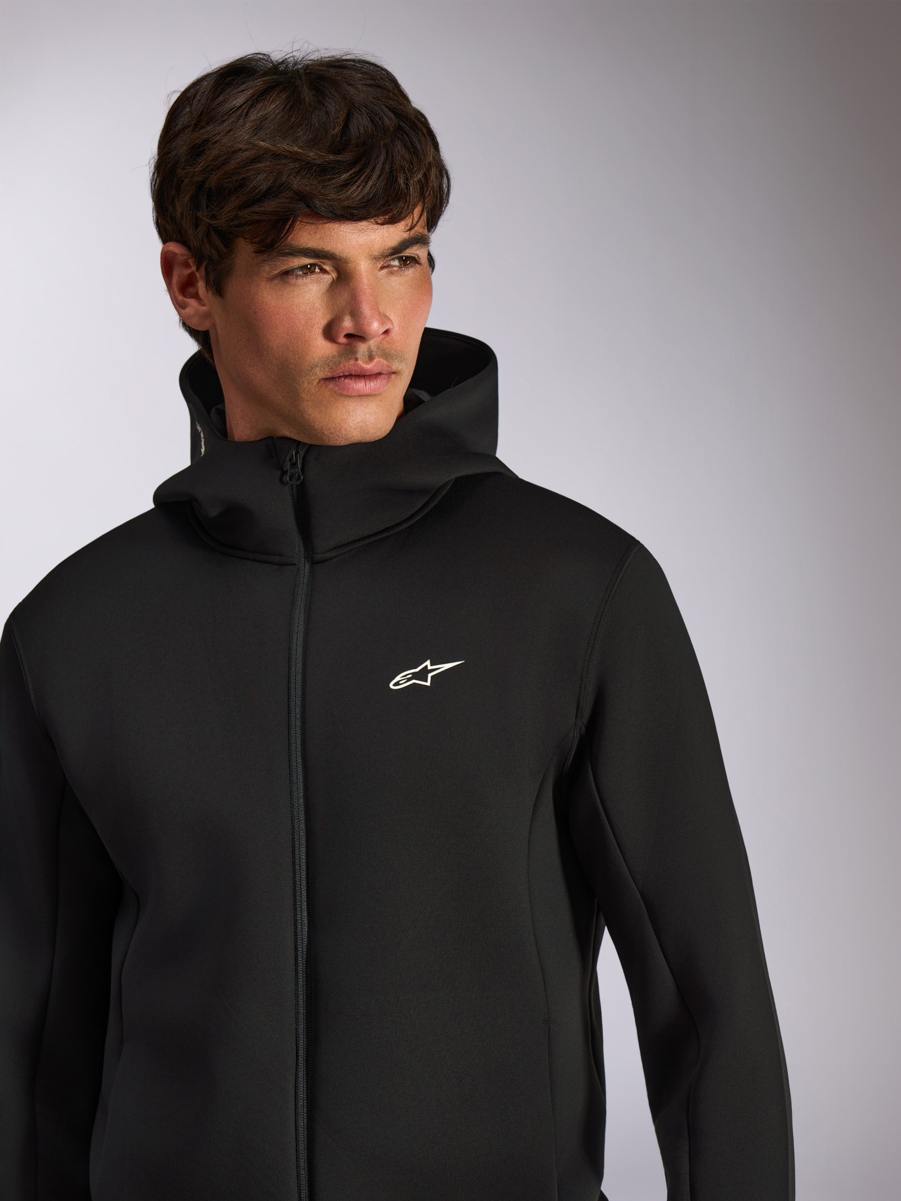 Alpinestars Cypher Hoodie, casual sportswear, black zip-front hoodie with white Astars logo on chest, high-neck hood design, worn by male model