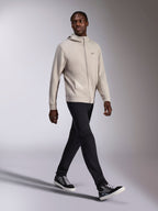 Alpinestars Cypher Hoodie, Cement gray full-zip fleece, high neck hood, small Astars chest logo, worn by a model walking, paired with black pants and black and gray sneakers, casual motorsport-inspired sportswear.