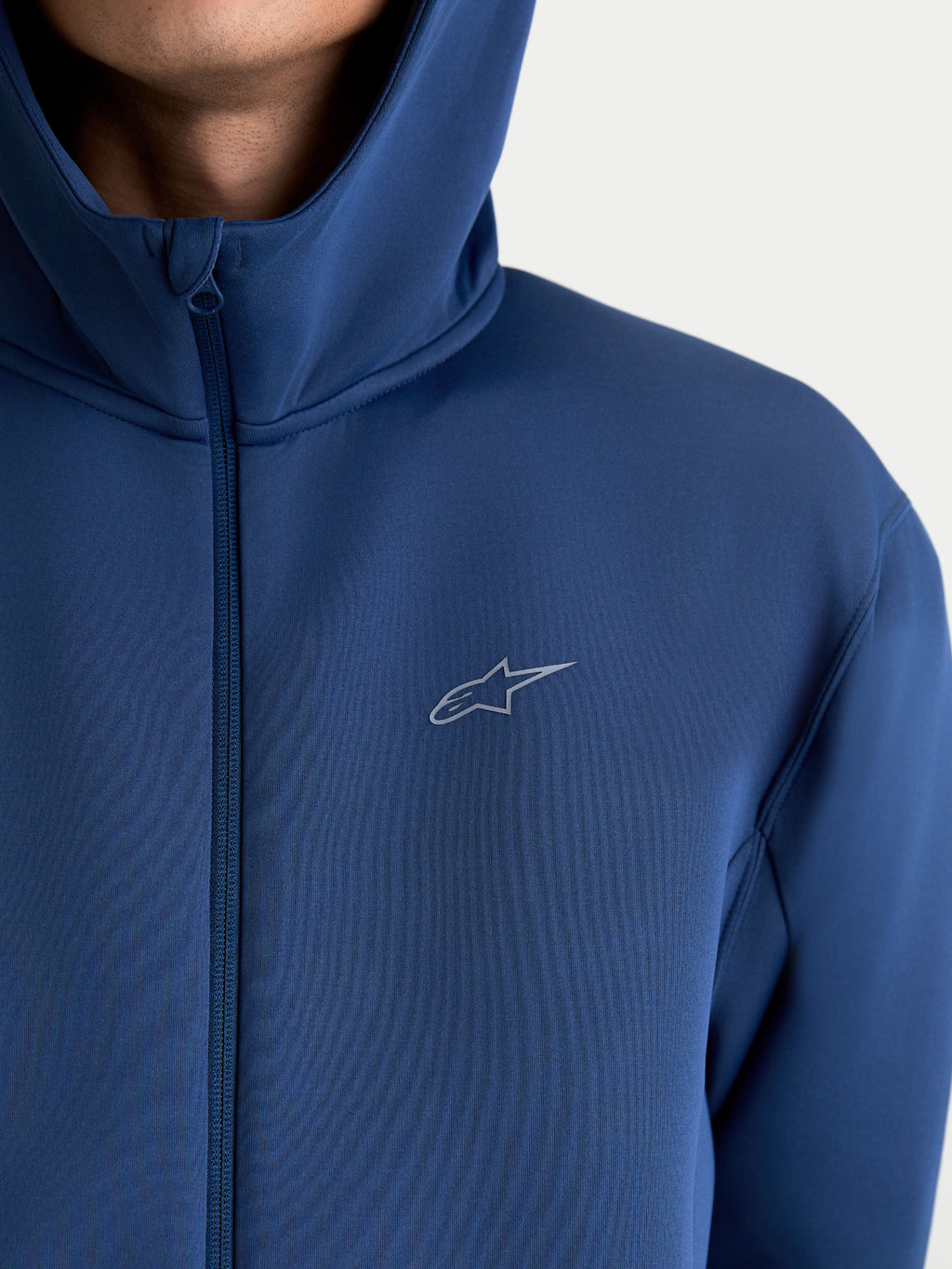 Alpinestars Camisola com capuz Cypher, hoodie de sportswear unissexo com fecho frontal, azul aço, tecido fleece técnico de dupla face, capuz de gola alta e logótipo Astars, vista de detalhe no modelo.