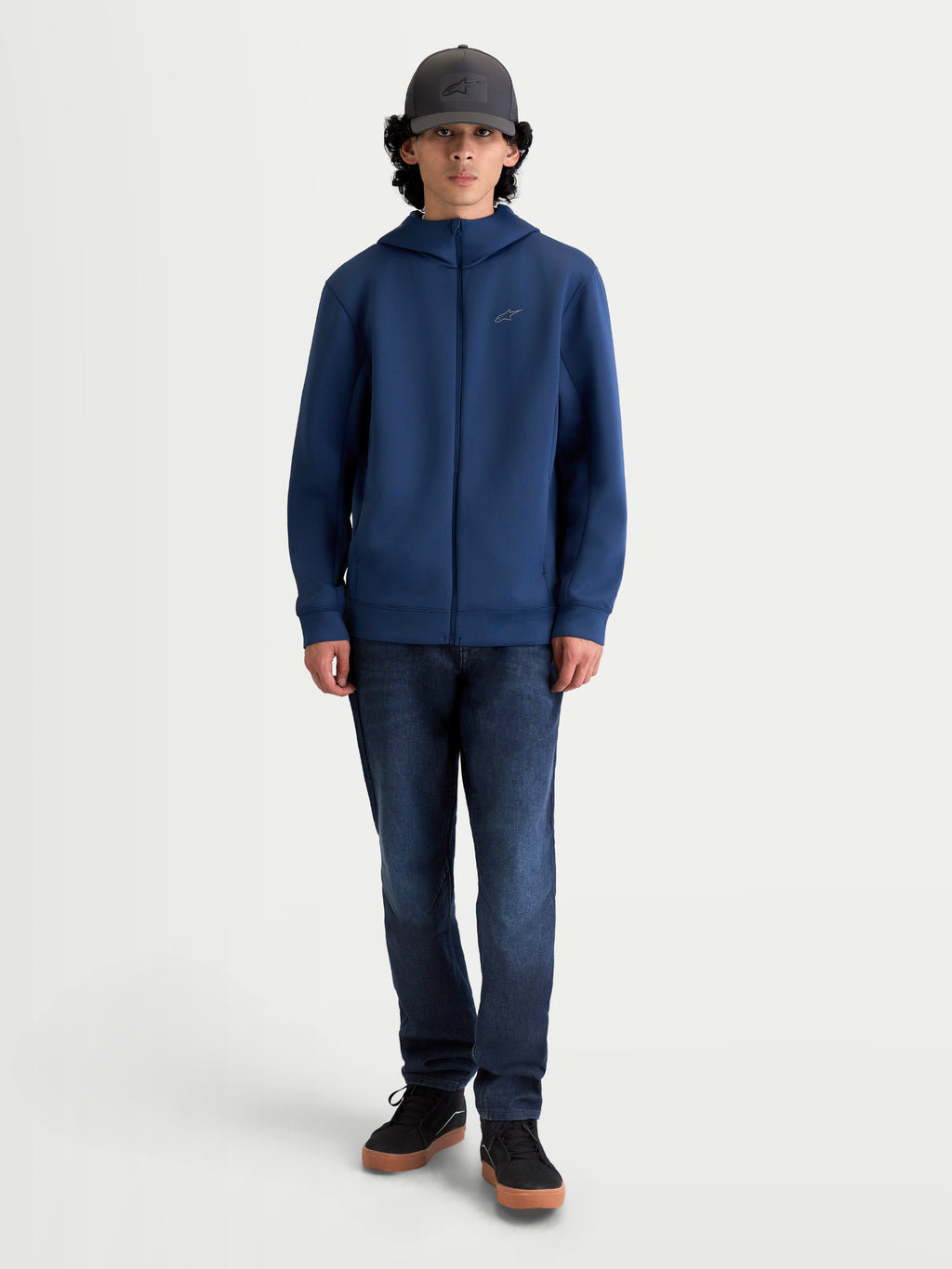 Alpinestars Camisola com capuz Cypher, hoodie de sportswear com fecho frontal para homem, azul aço, em tecido tri-blend de dupla face com capuz de gola alta e bolsos nas costuras, estilo casual inspirado no desporto motorizado em modelo.