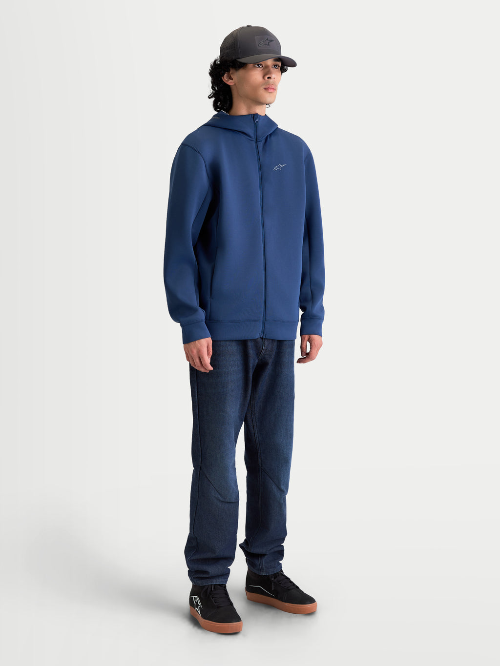 Alpinestars camisola com capuz Cypher, fleece sportswear com fecho frontal, unissexo, azul aço, tecido técnico tri-blend, capuz de gola alta forrado com malha e bolsos nas costuras, vista de corpo inteiro no modelo mostrando um ajuste aerodinâmico inspirado no motorsport.