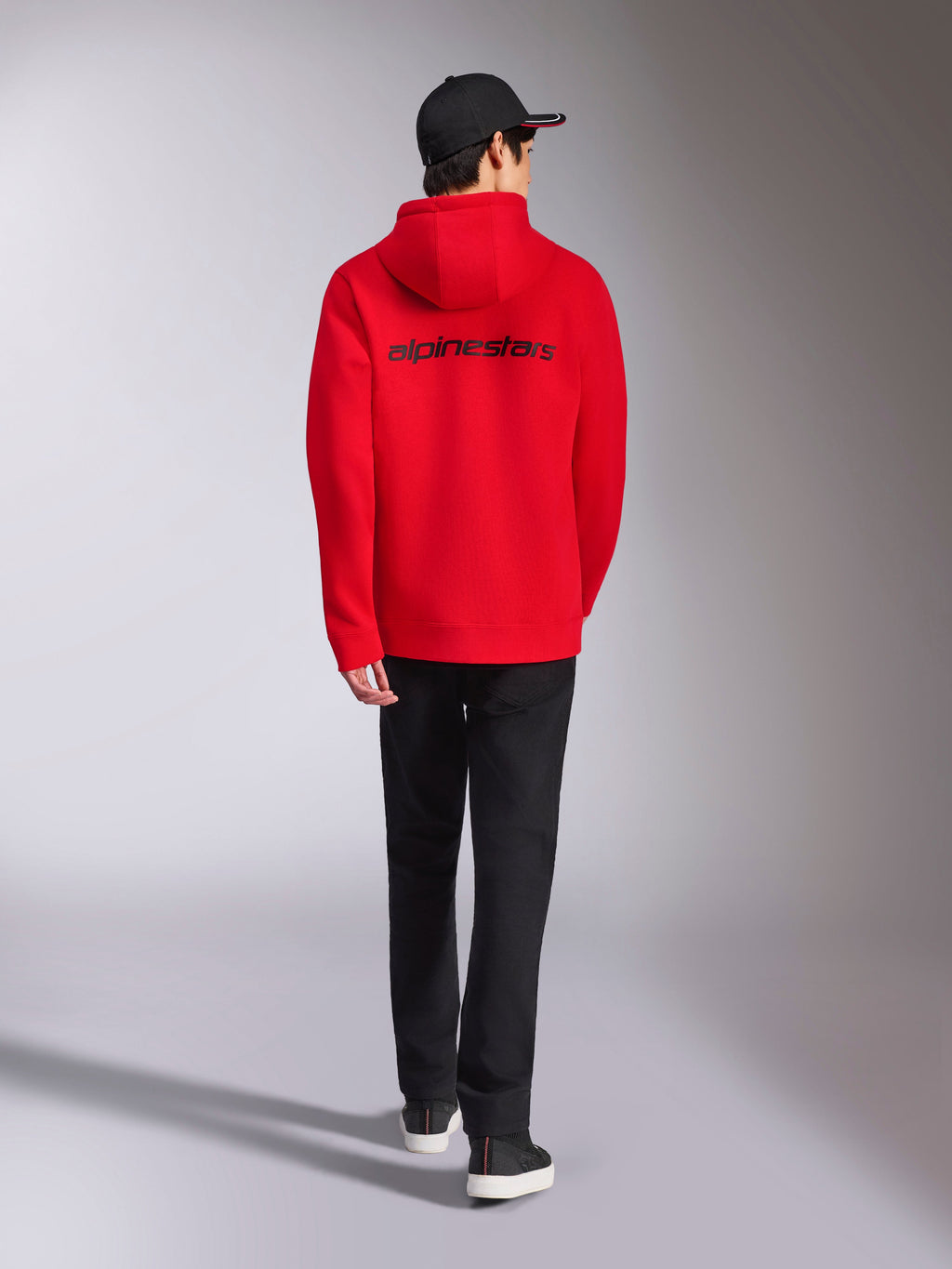 Alpinestars Transverse Hoodie, camisola com capuz vermelha, vista traseira com o logótipo Alpinestars em preto, estilo casual, combinada com boné preto e calças pretas
