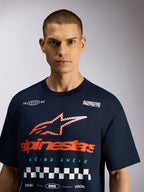 Alpinestars Aplomb Oversized CSF Tee, t-shirt de manga curta azul marinho, gráfico grande no peito com logótipo vermelho e padrão axadrezado branco, estilo casual streetwear inspirado nos desportos motorizados