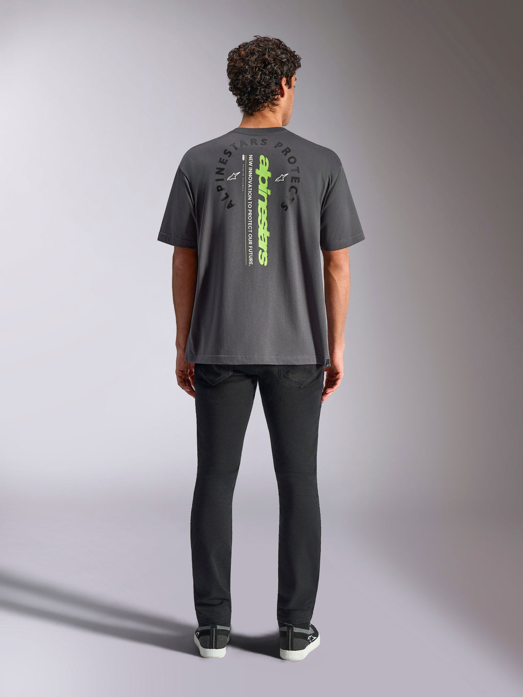 Alpinestars Overhang Oversized CSF Tee, Short Sleeve T-Shirt, Charcoal Gray, rear view featuring vertical neon green Alpinestars logo and graphic text, oversized fit, casual motorsport streetwear