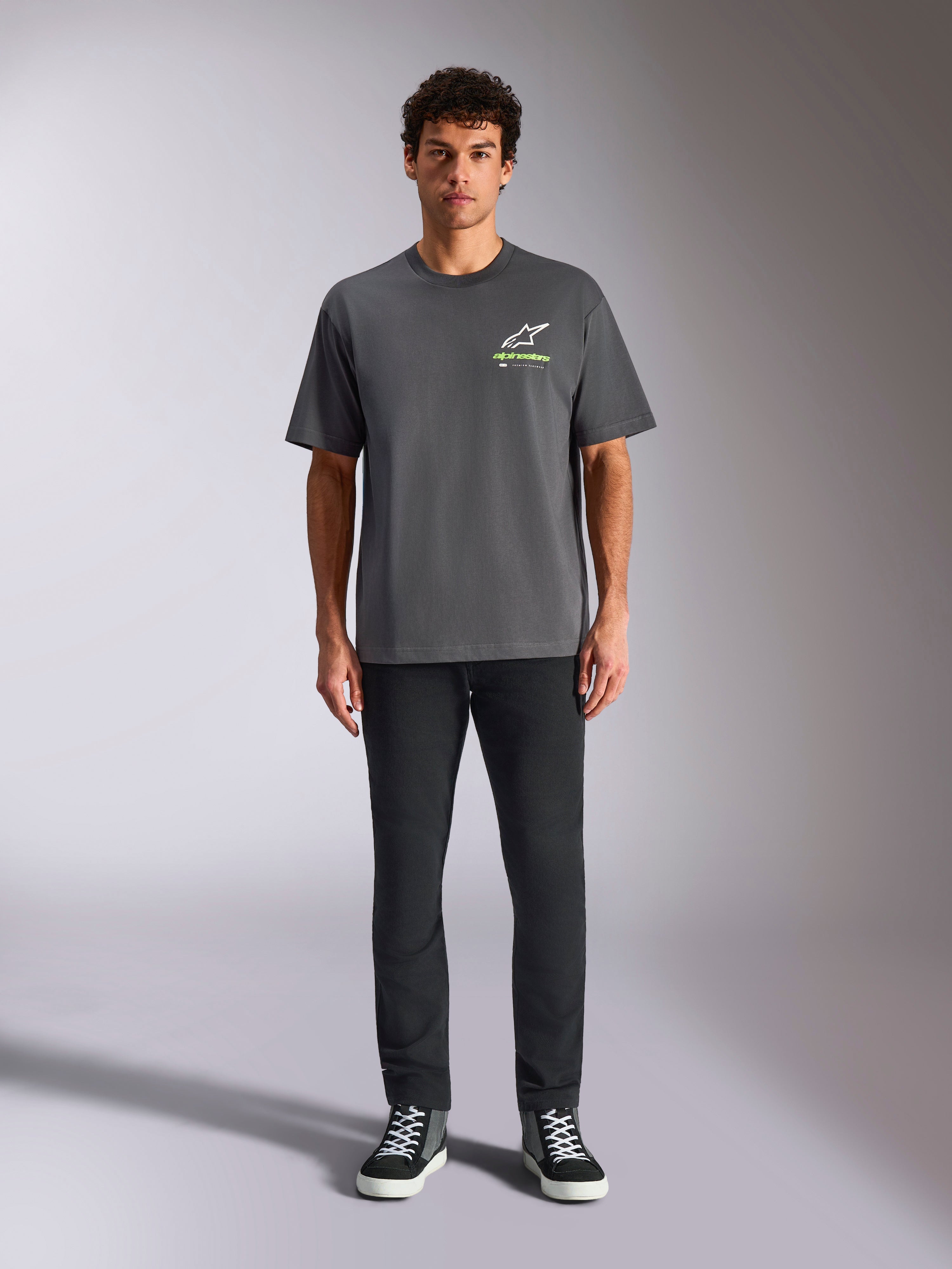 Alpinestars Overhang Oversized CSF Tee, Short Sleeve T-Shirt, Charcoal Gray, featuring a front white and lime green Alpinestars logo, worn by a model with black pants and sneakers, relaxed casual streetwear
