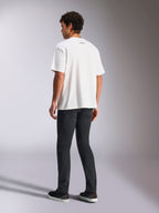 T-shirt Alpinestars Focused Oversized CSF, t-shirt de manga curta, branca, pequeno logótipo da palavra Alpinestars a preto na parte de trás da gola, usada com calças pretas, corte oversized, streetwear casual inspirado no desporto motorizado