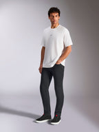 Alpinestars Focused Oversized CSF Tee, t-shirt de manga curta, branca, com um pequeno logótipo Astars preto no peito, usada por um modelo masculino com calças escuras e sapatilhas pretas, streetwear casual inspirado no desporto motorizado