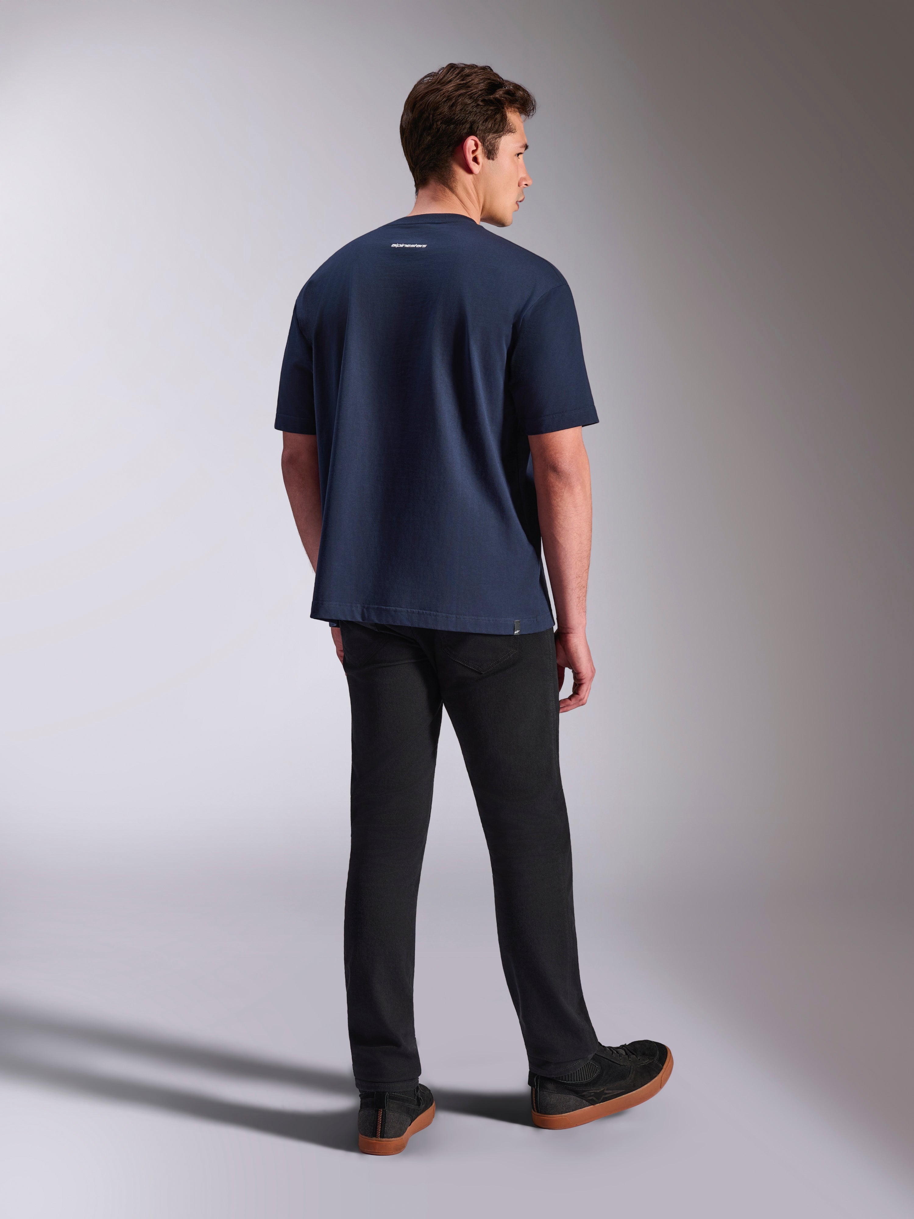 Alpinestars Focused Oversized CSF Tee, t-shirt de manga curta, azul-marinho, vista traseira com pequeno logótipo Alpinestars branco na gola, usada com calças pretas, vestuário casual lifestyle