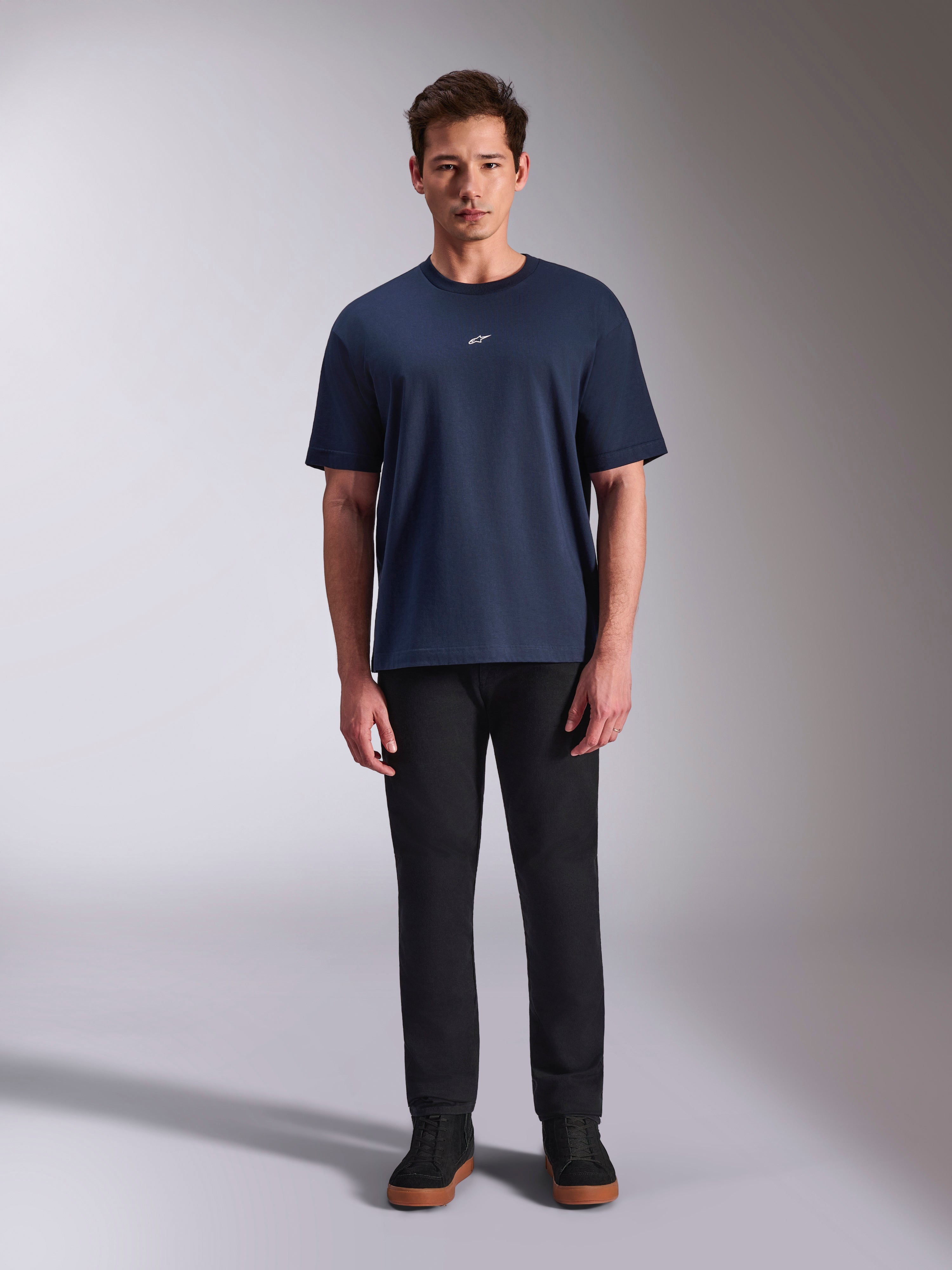 T-shirt Alpinestars Focused Oversized CSF, camisola de manga curta azul marinho, logótipo Astars branco pequeno no peito, corte oversized, combinada com calças e sapatilhas pretas, streetwear casual de motorsport