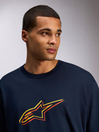Alpinestars Alter Oversized CSF Tee, t-shirt de manga curta, azul marinho, logótipo Astars com impressão em amarelo e laranja com desvio de cor, estilo casual streetwear usada por um modelo