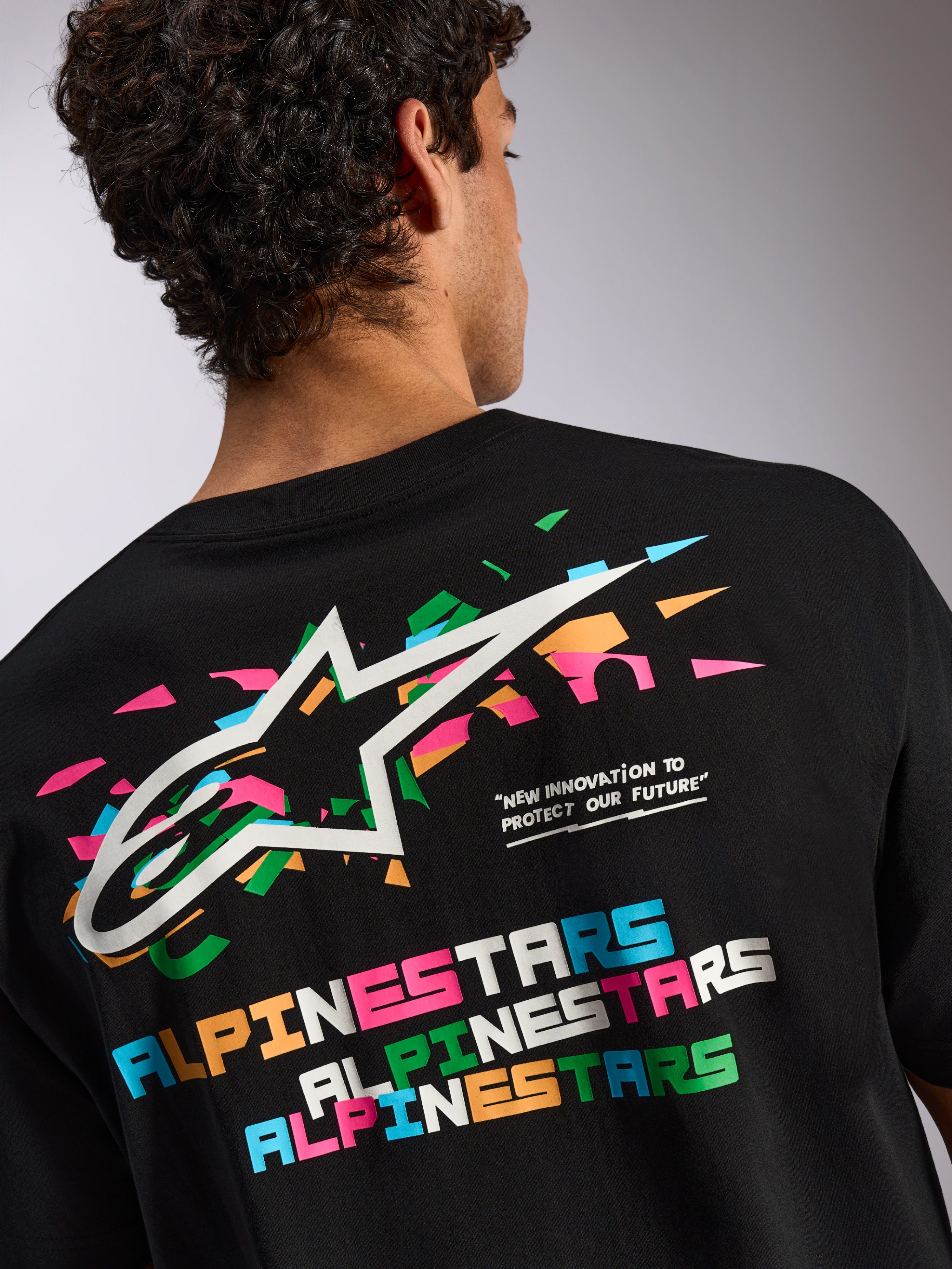 Alpinestars Wild Oversized CSF Tee, t-shirt de manga curta preta, gráfico grande nas costas com o logótipo Astars multicolorido vibrante e tipografia, roupa desportiva casual