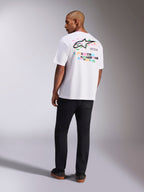 Alpinestars Wild Oversized CSF Tee, Short Sleeve T-Shirt, White, Rear view of model wearing oversized tee with vibrant multi-color Astars logo and stacked text on the back, casual motorsport-inspired streetwear