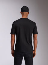 Alpinestars Ellipsoid CSF Tee, t-shirt de manga curta, preta, vista traseira no modelo, usada com um boné preto e calças escuras, streetwear casual inspirado no desporto motorizado