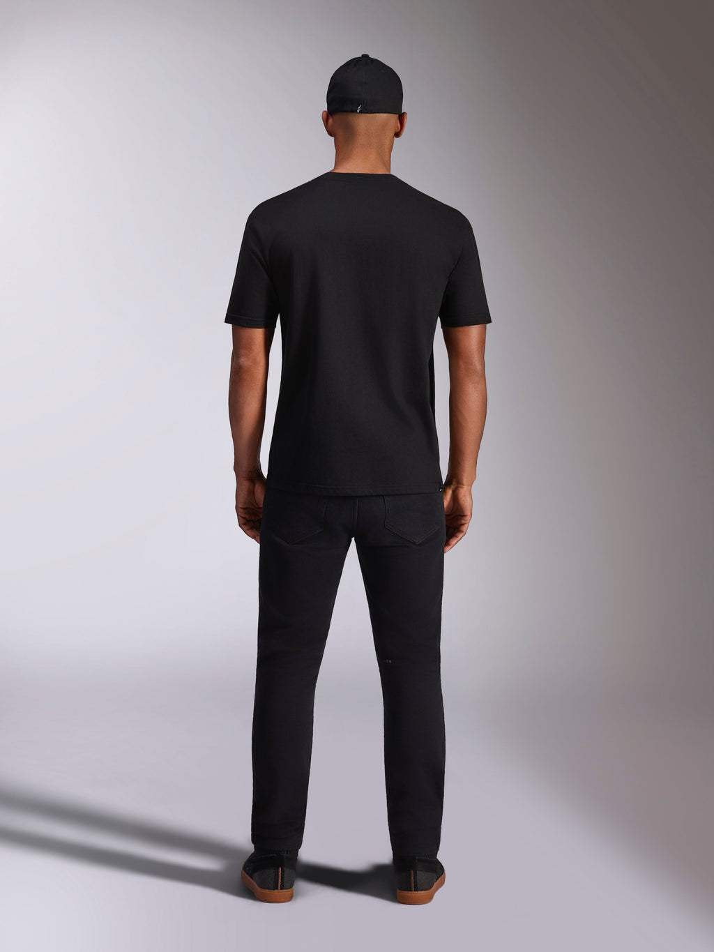 T-shirt Alpinestars Ellipsoid CSF, t-shirt de manga curta, preta, vista traseira usada por modelo com boné e calças pretas, streetwear casual inspirado no desporto motorizado