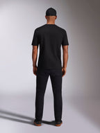T-shirt Alpinestars Ellipsoid CSF, t-shirt de manga curta, preta, vista traseira usada por modelo com boné e calças pretas, streetwear casual inspirado no desporto motorizado