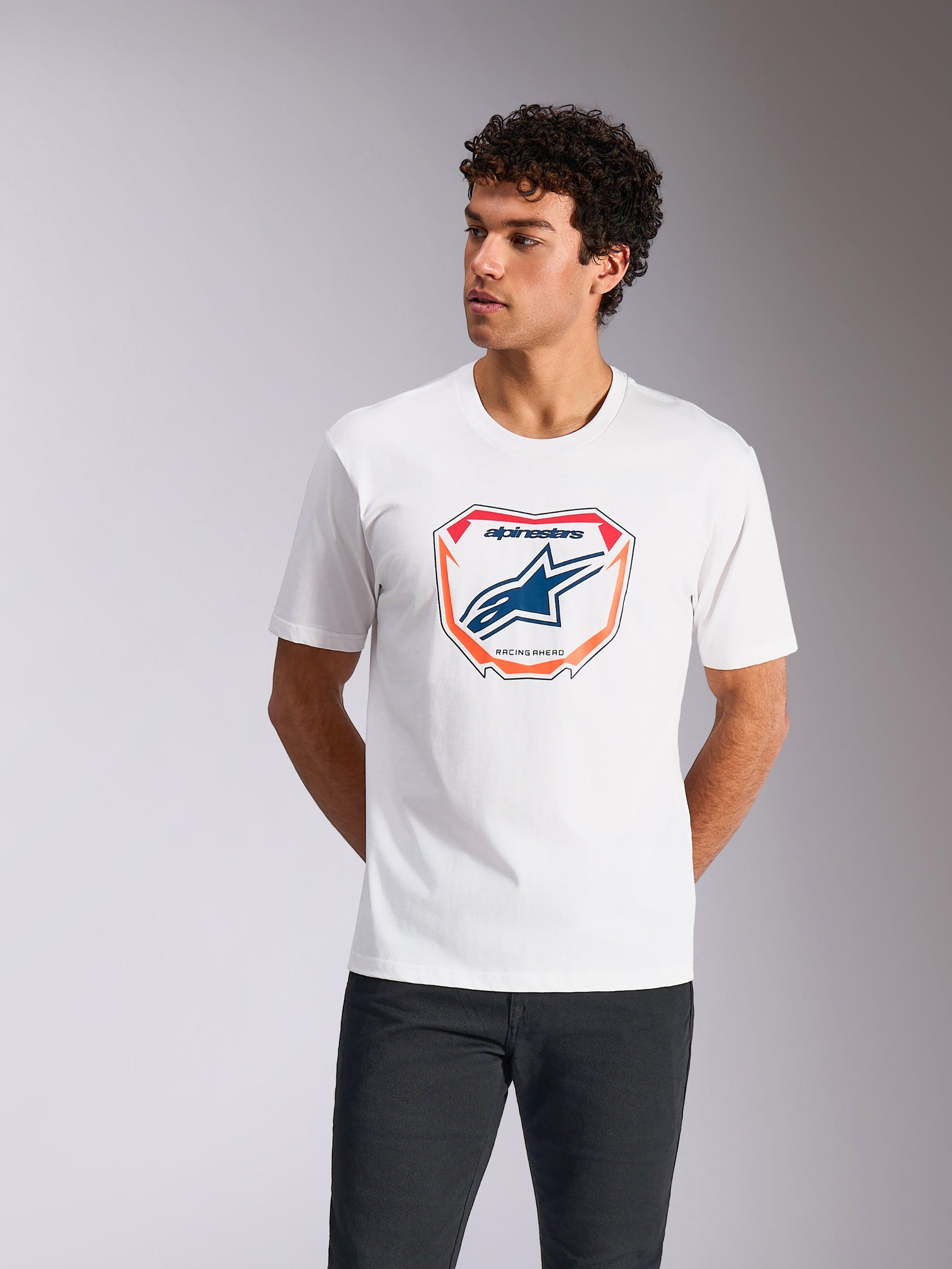 Alpinestars Plate CSF Tee, Short Sleeve T-Shirt, White, featuring a front Astars MX plate graphic with blue logo and orange border, worn by a model, Casual Motorsport Streetwear