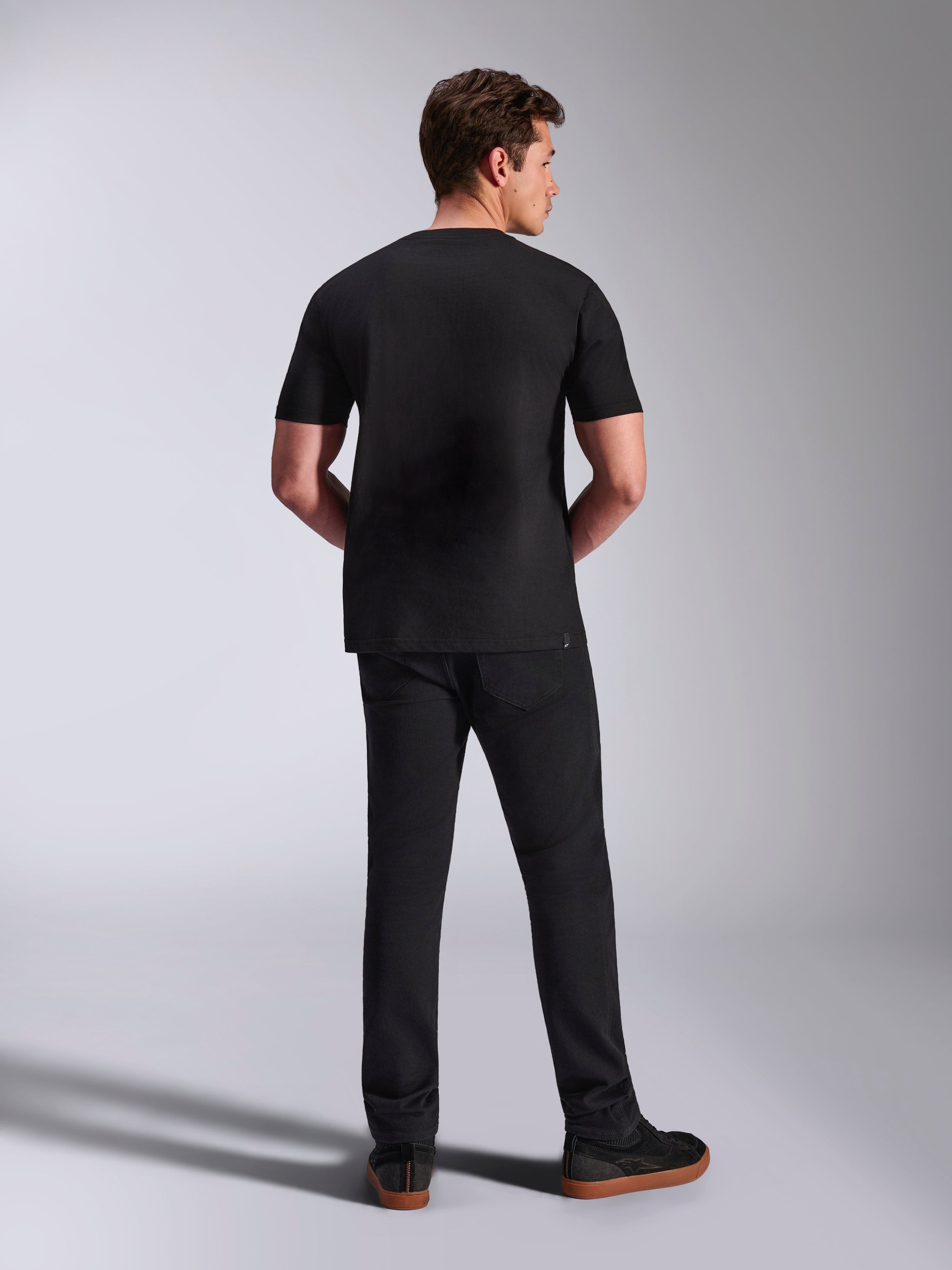 Alpinestars Abus CSF Tee, t-shirt de manga curta, preta, vista traseira no modelo com calças pretas, sportswear casual de desportos motorizados