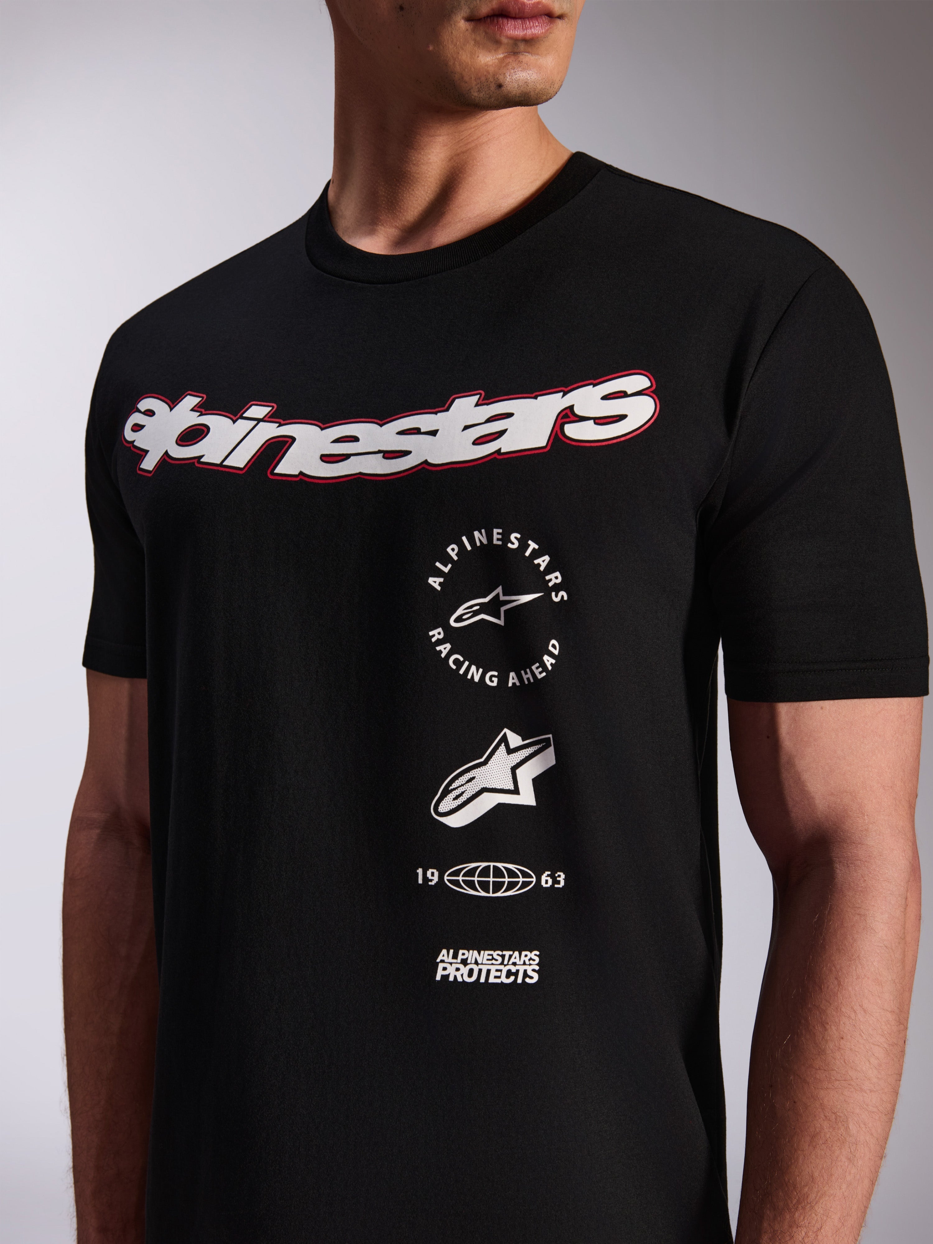 Alpinestars Abus CSF Tee, t-shirt de manga curta preta, logótipo branco de grandes dimensões no peito com contorno vermelho, logótipos gráficos empilhados verticalmente, streetwear casual de desportos motorizados