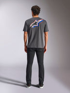 Alpinestars Angler CSF Tee, t-shirt de manga curta, cinzento escuro, logótipo Astars grande multicolorido nas costas com detalhes em vermelho e azul, vista traseira no modelo, streetwear casual de motorsport