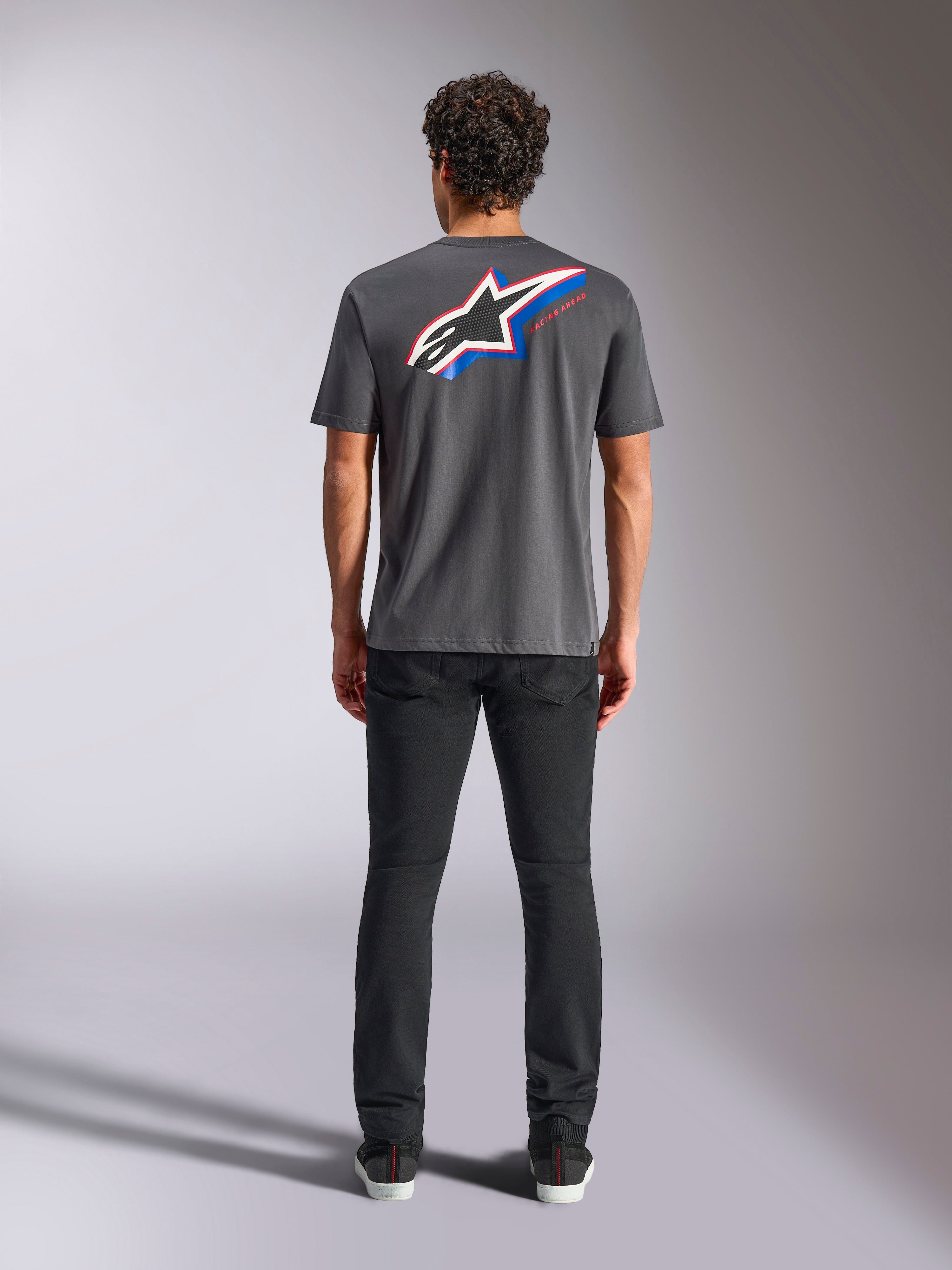 Alpinestars Angler CSF Tee, t-shirt de manga curta, cinzento escuro, logótipo Astars grande multicolorido nas costas com detalhes em vermelho e azul, vista traseira no modelo, streetwear casual de motorsport