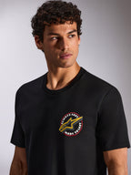 T-shirt Alpinestars Aorbit CSF, t-shirt de manga curta, preta, gráfico circular no peito "Always Fast Made to Last" com logótipo Astars amarelo, vestida por modelo, streetwear casual de desportos motorizados