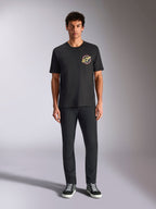 Alpinestars Aorbit CSF Tee, t-shirt de manga curta, preta, logótipo circular com o texto 'Always Fast Made to Last' no peito, usada por um modelo com calças pretas e sapatilhas, streetwear casual inspirado no desporto motorizado