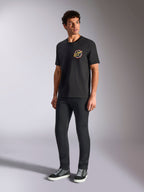 T-shirt Alpinestars Aorbit CSF, t-shirt de manga curta, preta, com um gráfico circular 'Always Fast Made to Last' no peito, usada por um modelo com calças escuras de corte justo e sapatilhas, streetwear casual inspirado no desporto motorizado