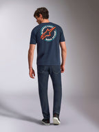 Alpinestars Aorbit CSF Tee, t-shirt de manga curta, azul-marinho, vista de costas num modelo com gráfico circular grande, logótipo Astars vermelho e texto 'Always Fast Made to Last', streetwear casual de desportos motorizados