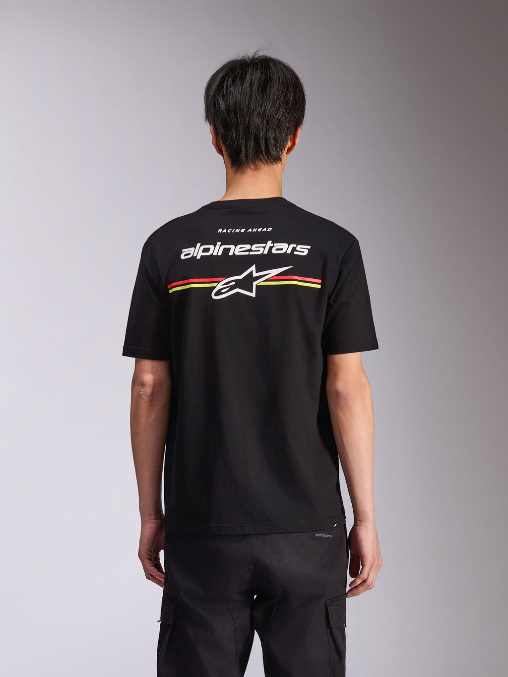 Alpinestars Lanes CSF Tee, t-shirt de manga curta, preta, vista traseira com logótipo Alpinestars em branco e estrela Astars com riscas vermelhas e amarelas, streetwear casual de desportos motorizados