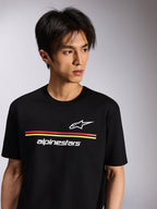Alpinestars Lanes CSF Tee, t-shirt de manga curta, preta, com logótipos Astars e Alpinestars brancos e riscas vermelhas e amarelas, vestuário casual motorsport usado por um modelo