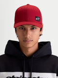 Alpinestars chapéu Pivot, boné de sportswear unissexo, vermelho escuro, vista frontal no modelo com patch do logótipo Astars bordado, aba curva, coroa estruturada e construção em sarja resistente.