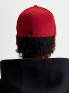 Alpinestars Chapéu Pivot, boné de basebol sportswear vermelho escuro, vista traseira no modelo mostrando a parte traseira flexível e a pequena etiqueta com o logótipo Astars.