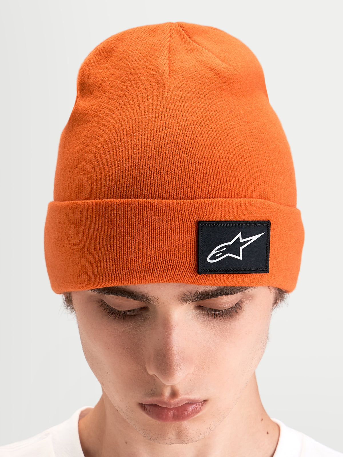 Gorro Alpinestars Augment Cuff, gorro de malha sportswear, laranja, com silhueta de ajuste profundo e patch tecido preto com o logótipo Astars na dobra, visto num modelo