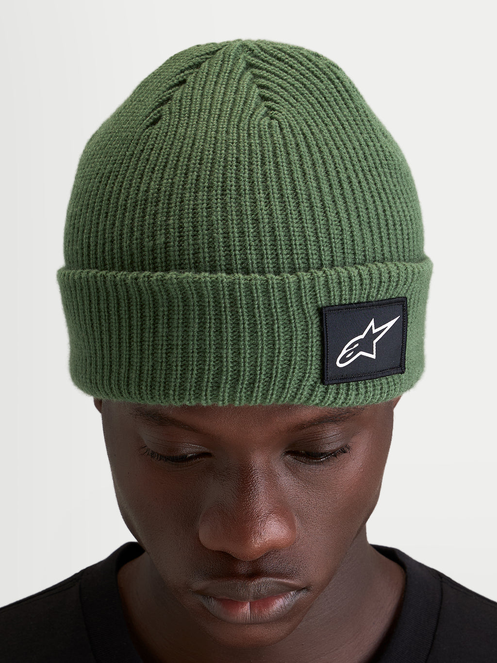 Alpinestars Unload Rib Cuff Beanie, winter sportswear knit hat, pea green, featuring a ribbed design and woven Alpinestars patch on the cuff worn by a model