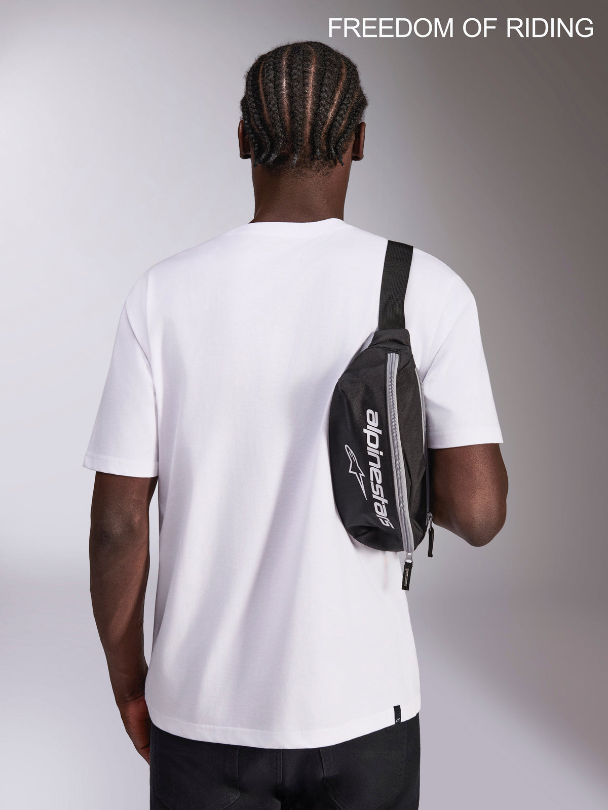 Alpinestars Only Linear Hip Bag, Urban Sportswear Waist Pack, Black and White, 2L capacity, 100% Polyester with Alpinestars logo branding, shown worn as a crossbody sling bag on a model for everyday travel and commuting.
