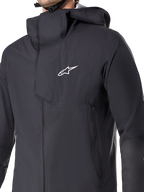 Alpinestars A-Dura Elite Waterproof Jacket, MTB Cycling Jacket, Black, featuring a 3-layer waterproof membrane, over-the-helmet hood, zippered pockets, and technical ripstop texture for mountain bike trail riding