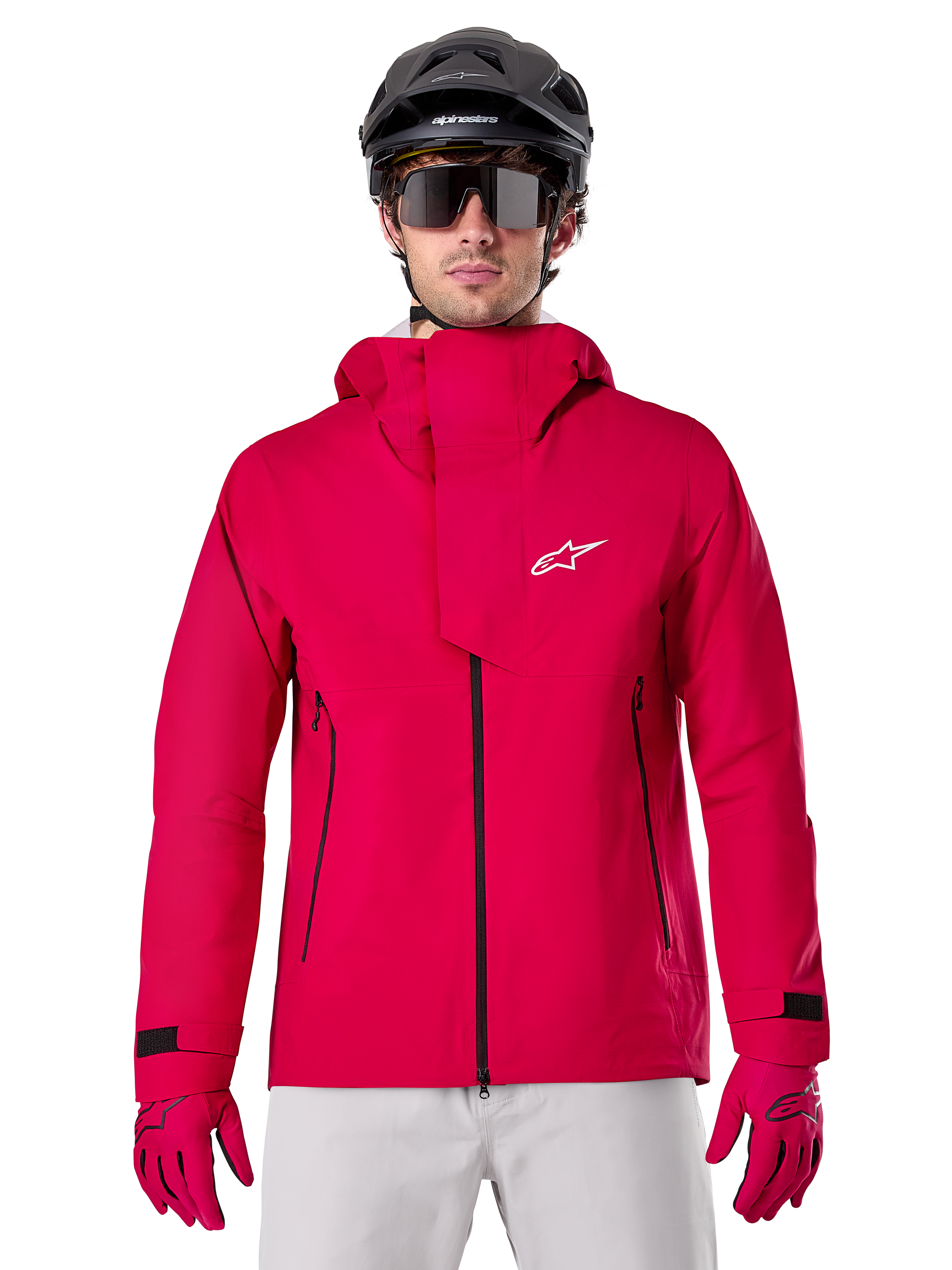 Alpinestars A-Dura Elite Waterproof Jacket, casaco de chuva para BTT, vermelho fluo, gola alta com logótipo Alpinestars branco, detalhes de fechos pretos, usado com luvas a condizer e capacete de ciclismo preto, equipamento técnico de ciclismo impermeável