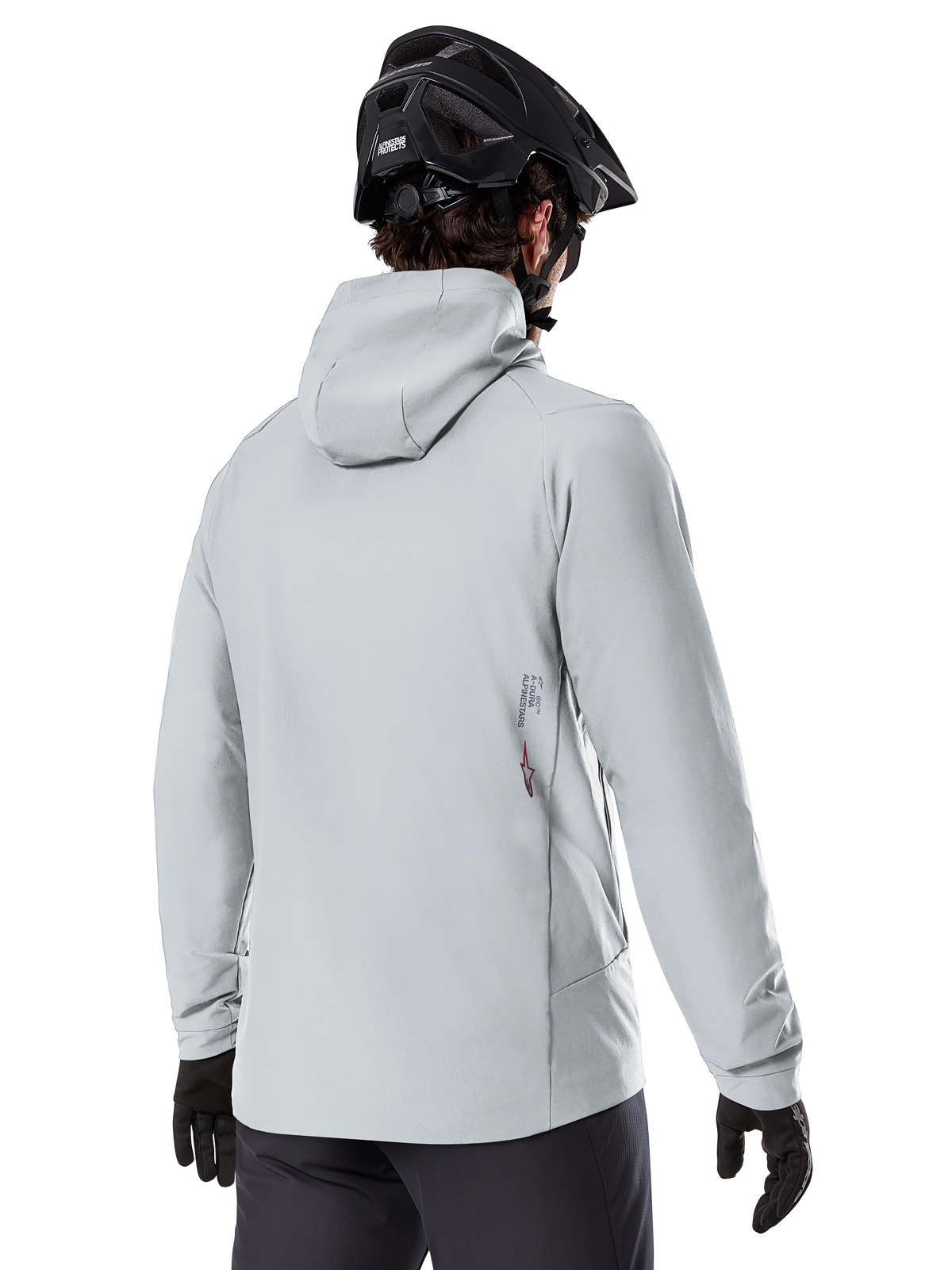 Alpinestars A-Dura Thermal Jacket, Cinzento Titanium, vista traseira de um ciclista a usar o casaco térmico com capuz, combinado com um capacete de BTT preto e luvas pretas, com um pequeno logótipo Alpinestars na parte inferior das costas, concebido para a prática de BTT em climas frios.