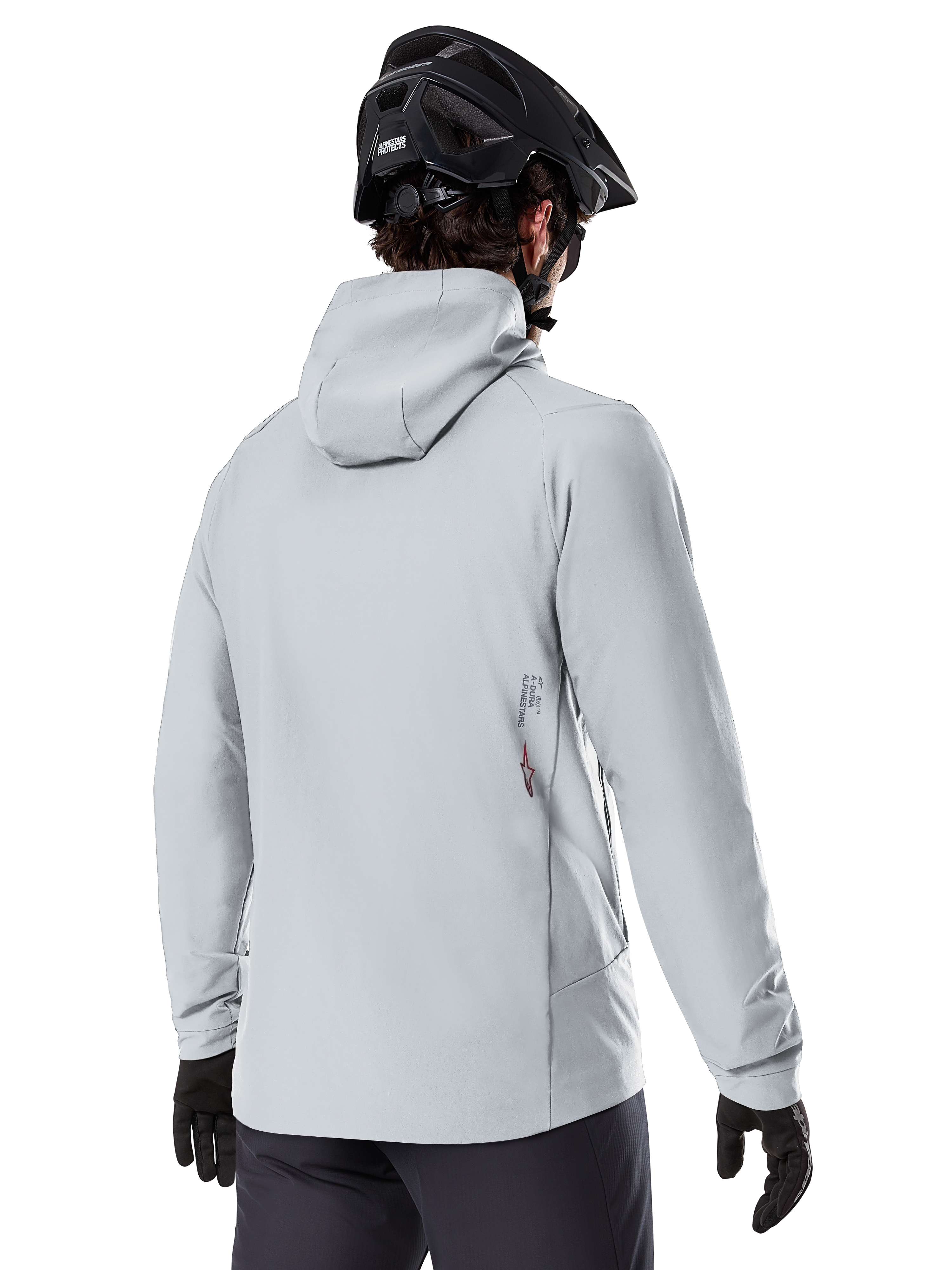 Alpinestars A-Dura Thermal Jacket, Cinzento Titanium, vista traseira de um ciclista a usar o casaco térmico com capuz, combinado com um capacete de BTT preto e luvas pretas, com um pequeno logótipo Alpinestars na parte inferior das costas, concebido para a prática de BTT em climas frios.
