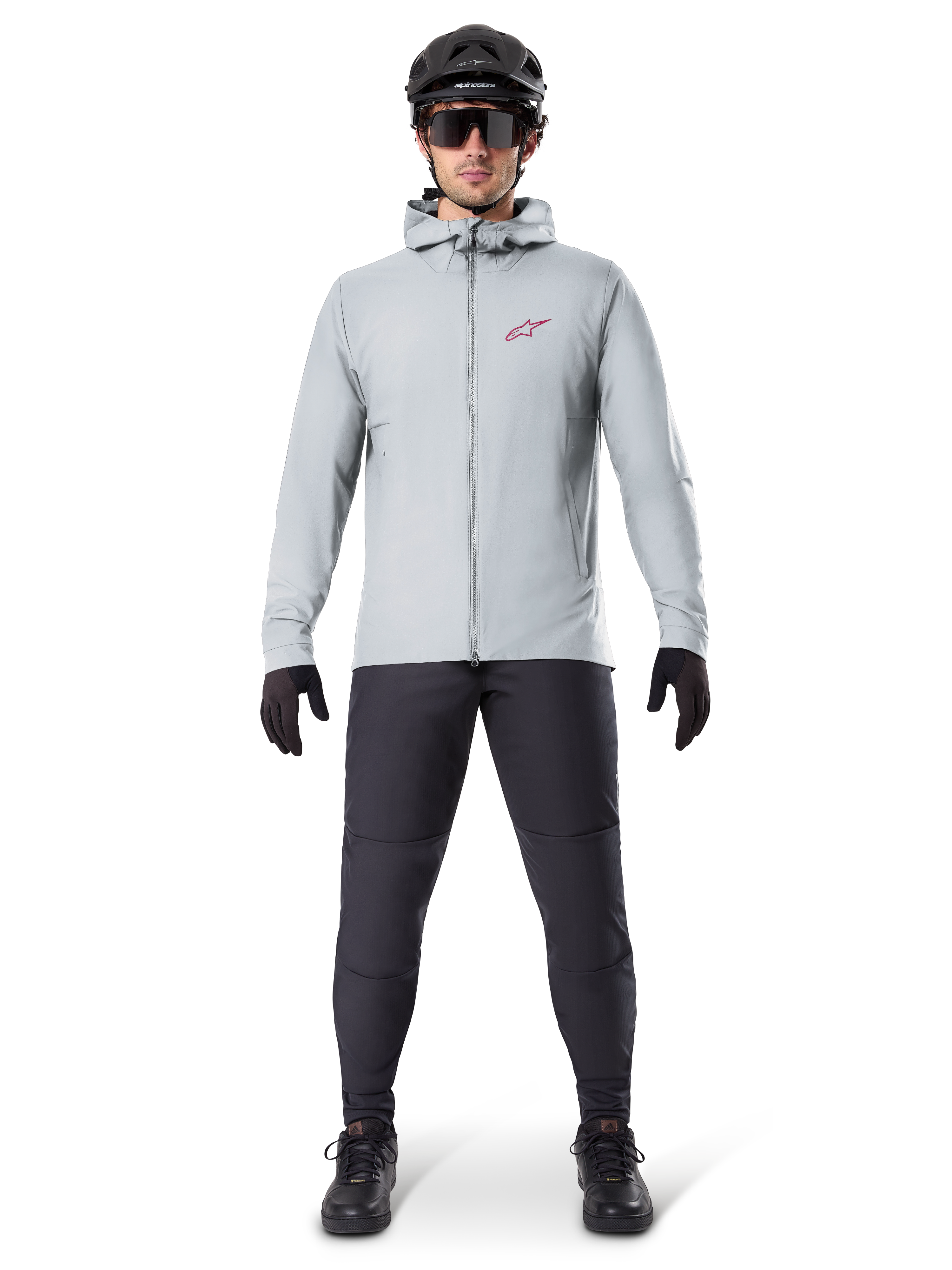 Casaco Térmico Alpinestars A-Dura, cinzento Titanium, casaco de ciclismo usado com calças de BTT pretas, luvas e capacete, com um pequeno logótipo de estrela vermelha no peito e fecho de correr frontal completo, equipamento isolado leve para condução fora de estrada