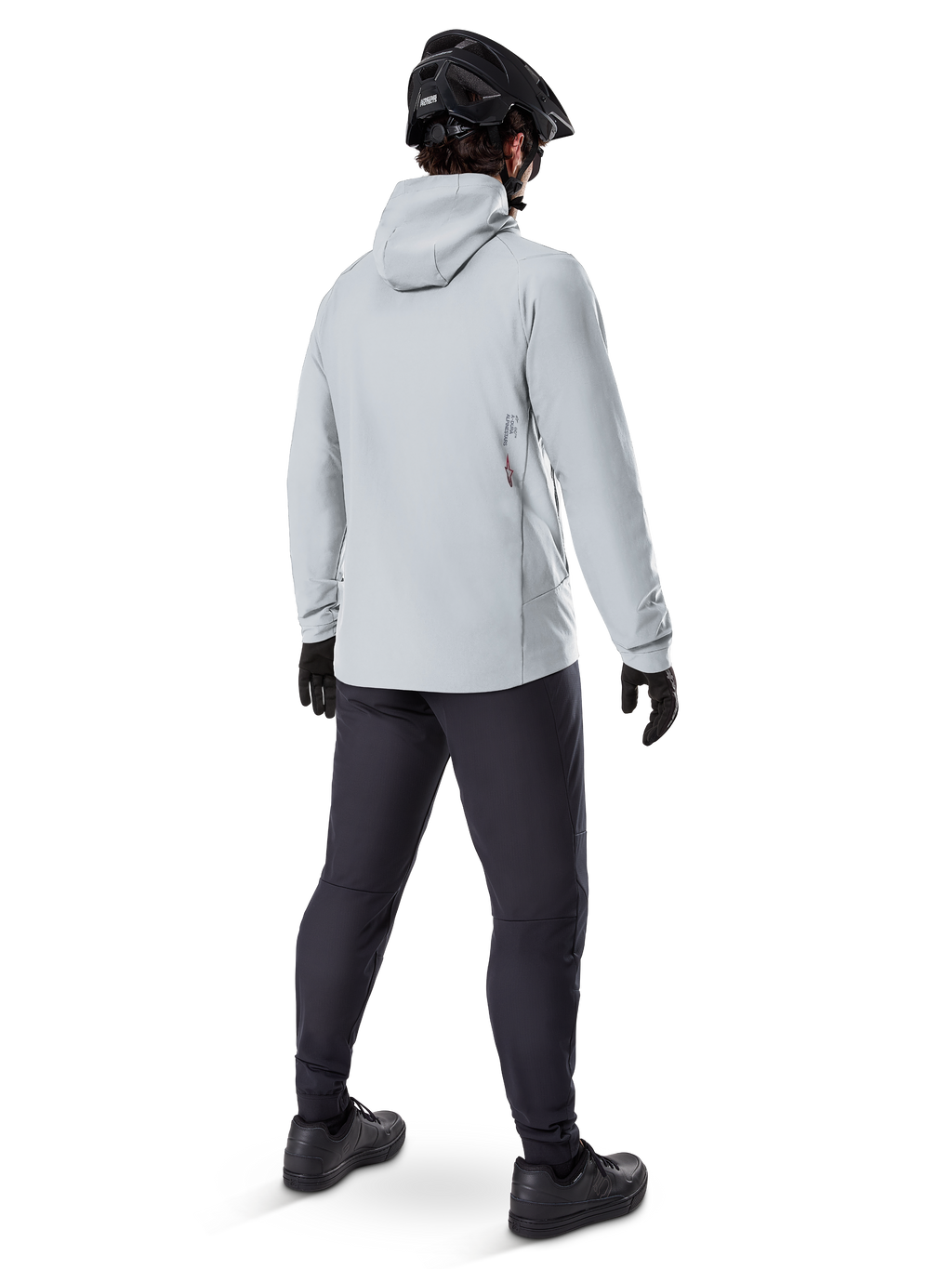 Casaco Térmico Alpinestars A-Dura em Titanium, vista traseira de ciclista masculino a usar casaco térmico cinzento claro com capuz, combinado com capacete de BTT preto, luvas pretas e calças cinzento-escuras, equipamento funcional de ciclismo de montanha.