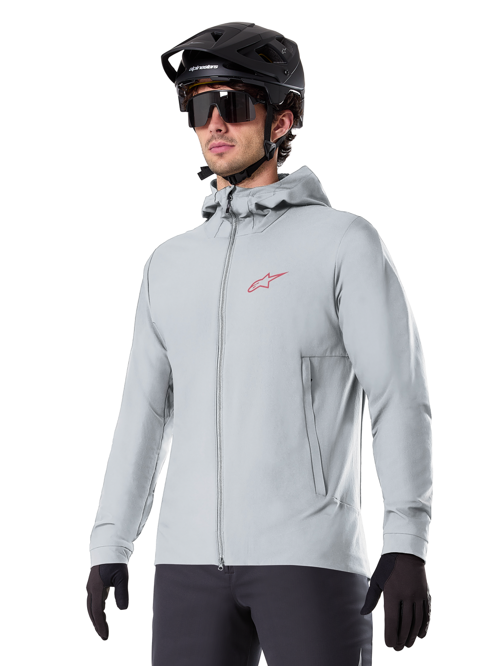 Alpinestars A-Dura Thermal Jacket, casaco térmico de ciclismo em cinzento claro, design com capuz e um pequeno logótipo vermelho, usado com capacete e luvas pretas, vestuário técnico de BTT para condução em tempo frio