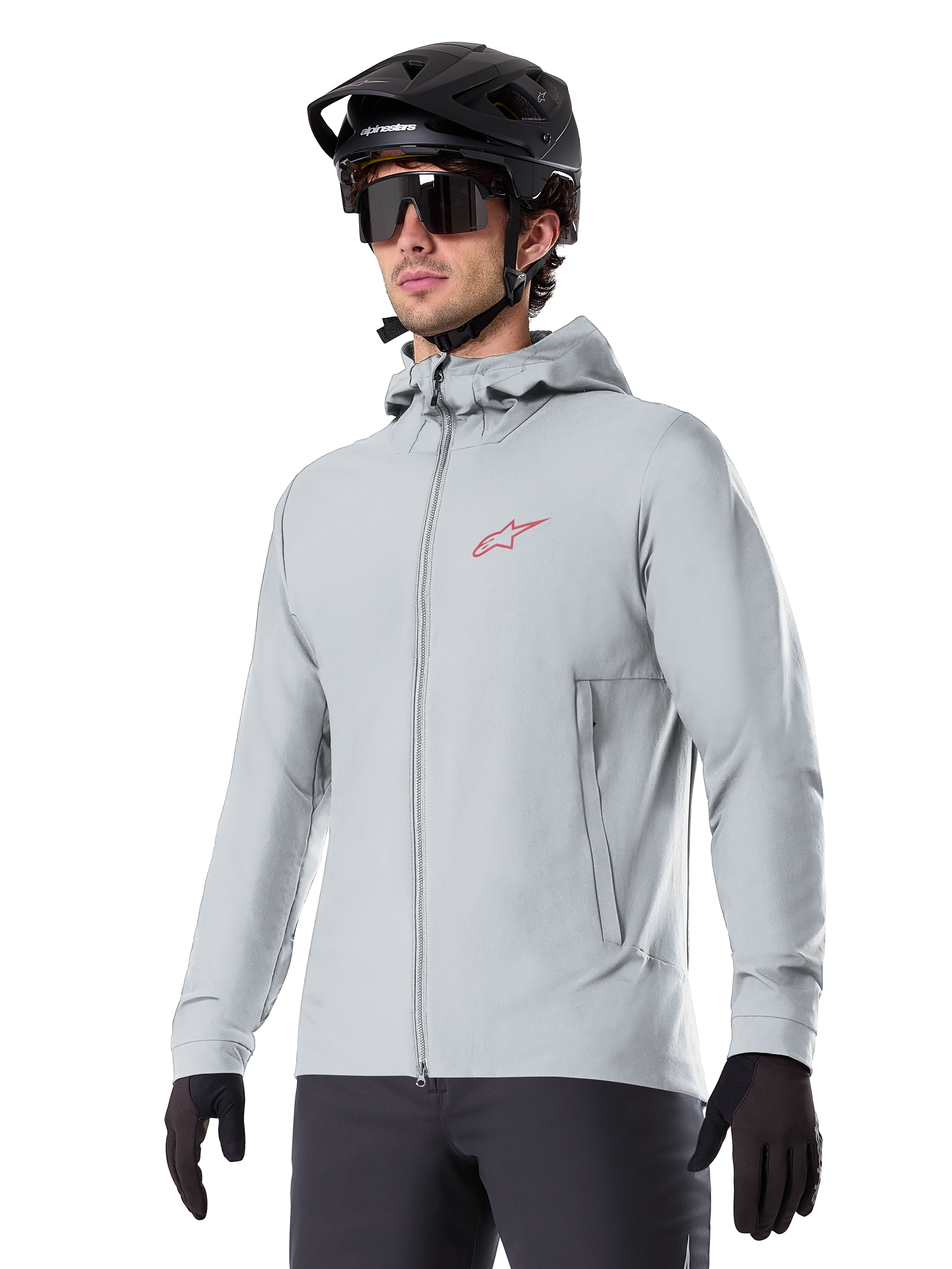 Alpinestars A-Dura Thermal Jacket, casaco térmico de ciclismo em cinzento claro, design com capuz e um pequeno logótipo vermelho, usado com capacete e luvas pretas, vestuário técnico de BTT para condução em tempo frio