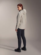 Alpinestars Stella A-Dura Thermal Jacket in Titanium Gray, three-quarter rear view of a woman wearing the insulated hooded cycling jacket with black MTB pants, studio shot showing the regular fit and pocket detail.
