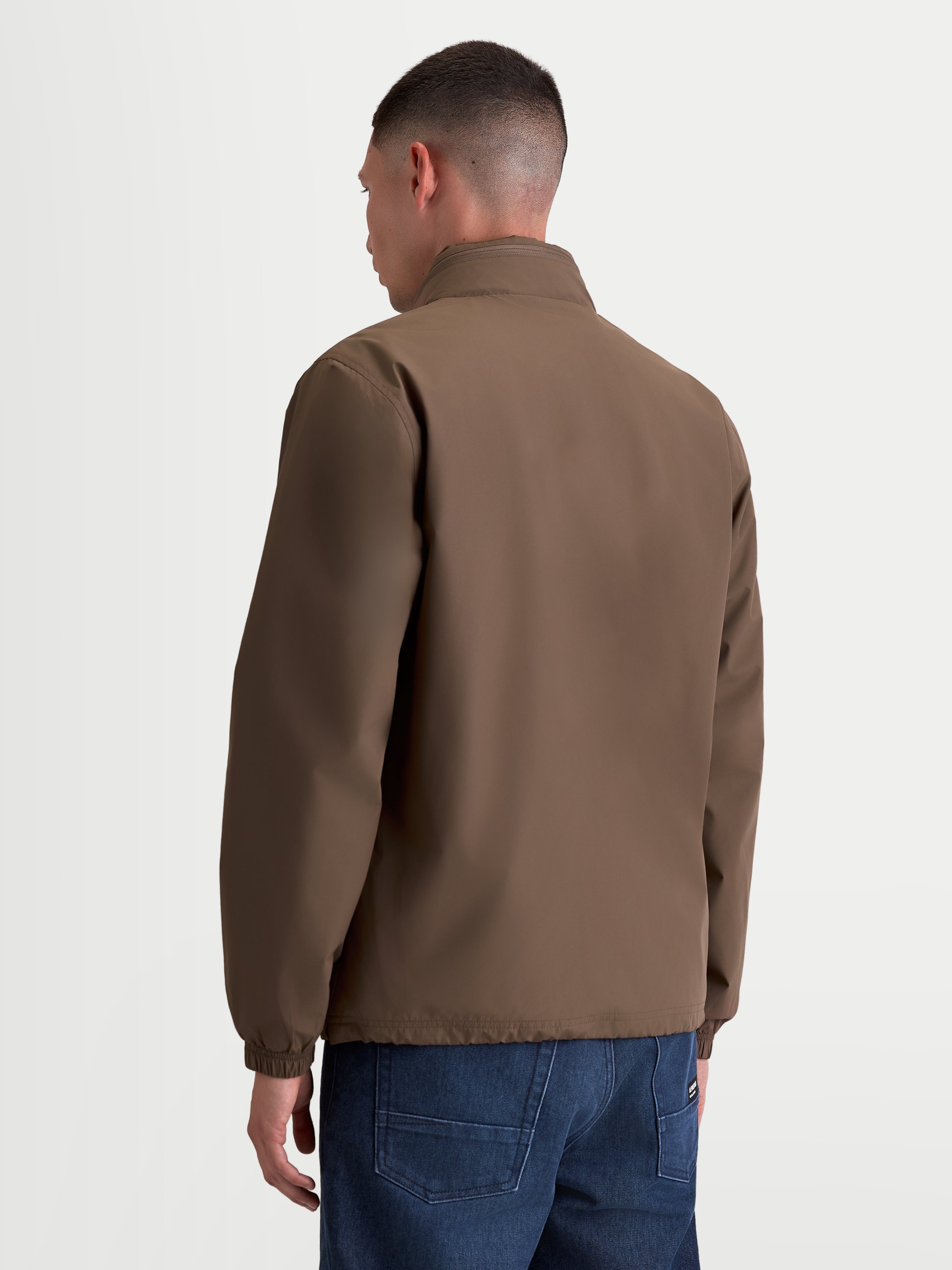 Alpinestars Casaco Overhaul Racer, casaco sportswear leve para homem, castanho, material têxtil em poliéster, vista traseira realçando a silhueta simples e gola alta com capuz oculto.