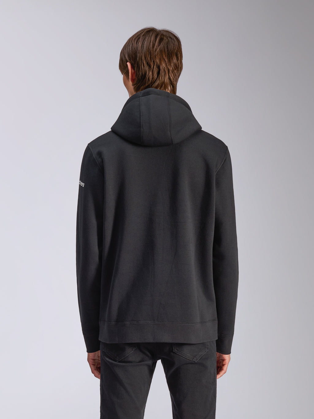 Alpinestars Frontal Hoodie, preto, vista traseira de uma sweatshirt casual, com capuz forrado, bainha canelada e logótipo branco na manga, streetwear inspirado no desporto motorizado