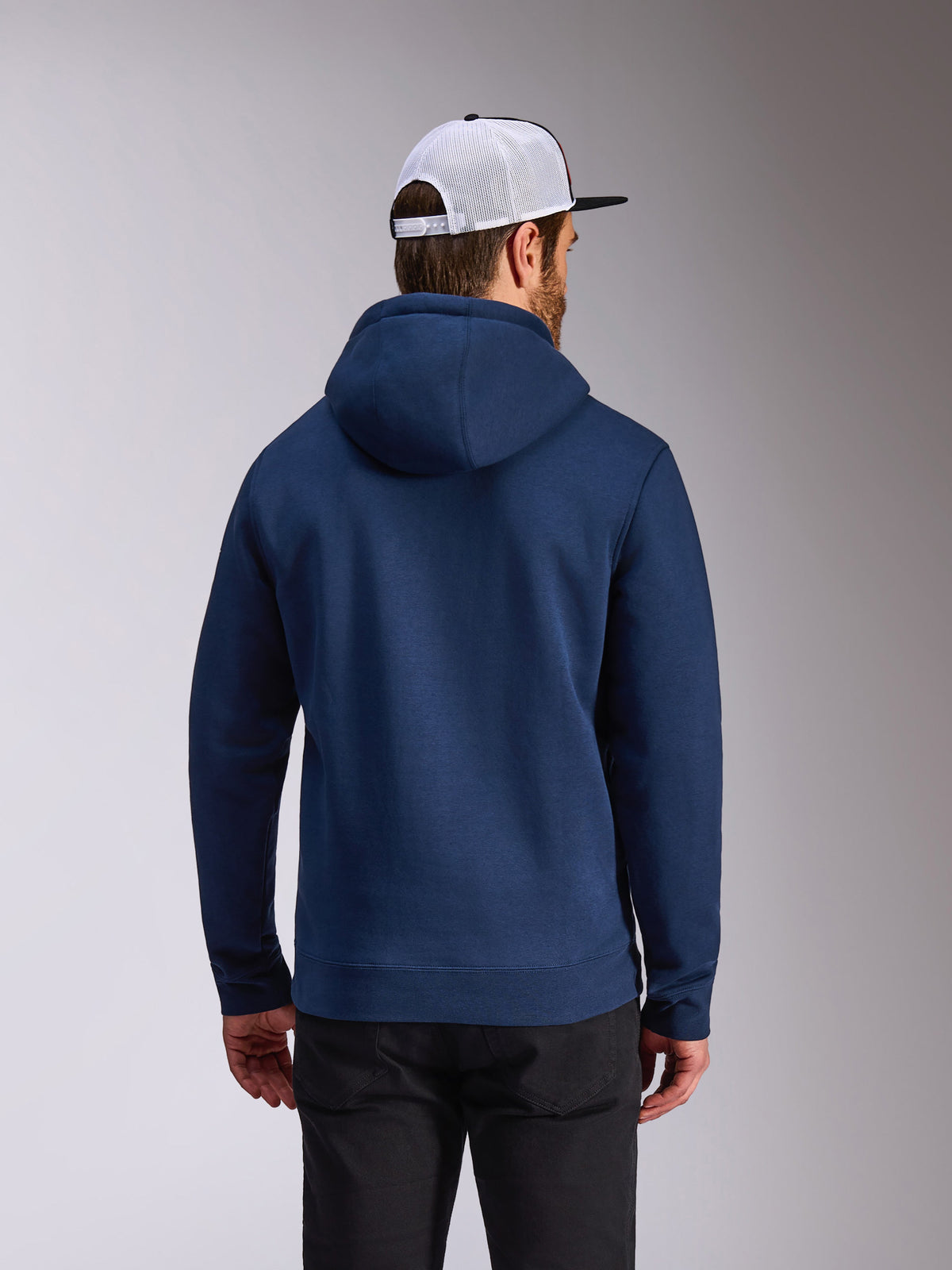 Alpinestars Frontal Hoodie, hoodie de lã polar azul-marinho, vista traseira de streetwear casual, usado com calças pretas e um boné de rede branco e preto, design moderno inspirado no desporto motorizado