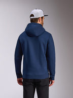 Alpinestars Frontal Hoodie, hoodie de lã polar azul-marinho, vista traseira de streetwear casual, usado com calças pretas e um boné de rede branco e preto, design moderno inspirado no desporto motorizado